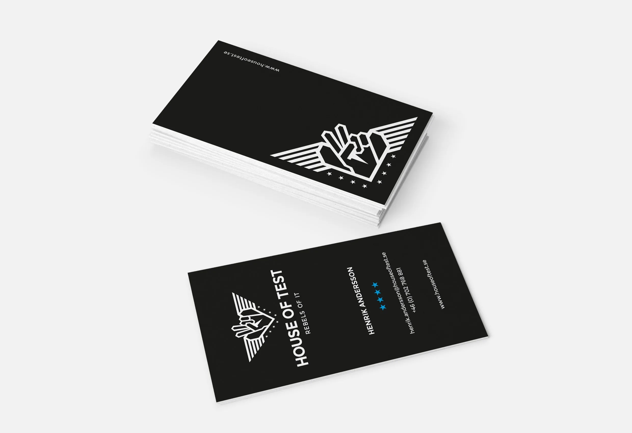 Svarta visitkort med House of Tests logotyp, en hand som visar peace-tecken med vingar