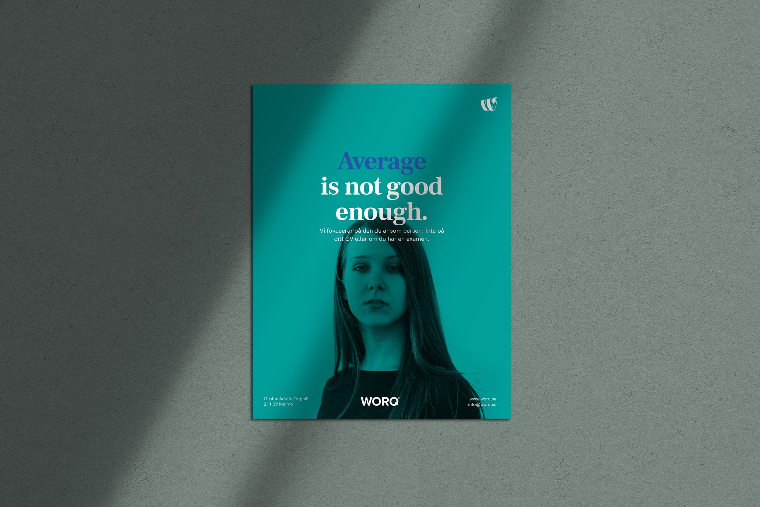 En grön affisch för Worq med ett porträtt och texten ”Average is not good enough.”