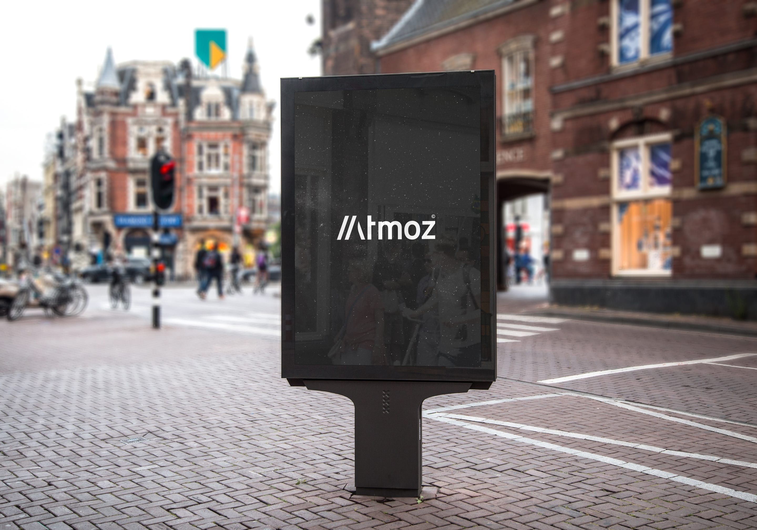 En reklampelare på en gata med Atmoz logotyp i vitt på svart